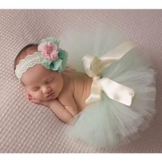 a newborn baby wearing a green and white tutu