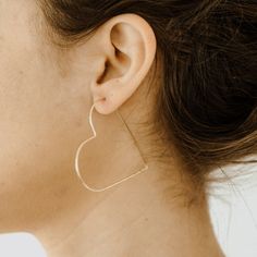 Love hearts? You're in luck; we do too. These slide-thru earrings are lightweight and so unique! The thin geometric shape hangs from your ear, creating a gorgeous heart shape from the side. Materials: 14k Gold Fill, 14k Rose Gold Fill, Sterling silver Measurements: 2"L x 1.9"W Love Hearts, Ear Rings, Handcrafted Earrings, Earrings Collection, Heart Earrings, Heart Shape, Pretty Things, Geometric Shapes, Gold Filled