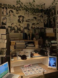 a desk with two laptops and pictures on the wall