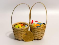 two baskets filled with different colored candies next to a gold heart shaped candy bar