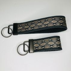 two black and white snakeskink keychains with metal rings on each side