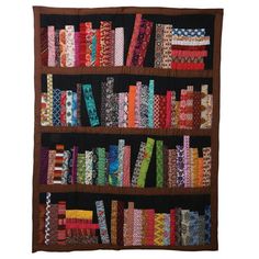 a book shelf filled with lots of different types of fabrics on top of each other