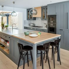 a kitchen island with stools in front of it