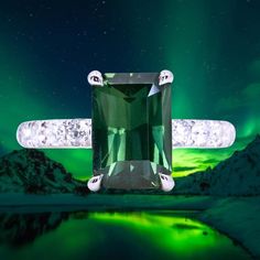 an emerald colored ring with diamonds in front of a green aurora boret sky background