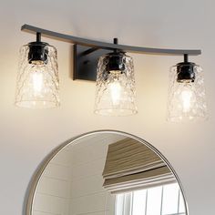 a bathroom vanity with three lights and a mirror