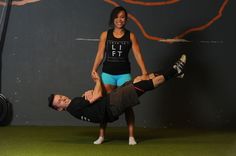 a man is doing a handstand on the ground as a woman stands next to him