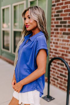 - This casual top is a trendy update to a timeless closet staple! - Lightweight material - A collared neckline - A button-up front - Short sleeves with rolled cuffs - Gathered detail at the shoulders and on the back - A relaxed silhouette that ends in a rounded hemline Blue Summer Blouse With Collared Neckline, Blue Collared Blouse For Summer, Blue Collared Neckline Summer Blouse, Trendy Blue Top With Collared Neckline, Trendy Blouse With Collared Neckline, Blue Collared Blouse For Spring, Trendy Blue Collared Blouse, Trendy Collared Blue Blouse, Versatile Collared Top For Business Casual