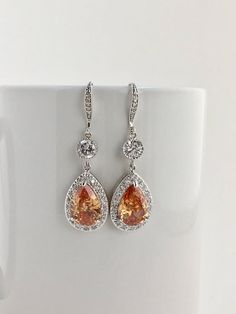 I've created these luxury morganite cubic zirconia bridal teardrop set rhodium plated brass setting. This set includes: # Luxury morganite cubic zirconia bridal teardrop earrings in rhodium plated brass setting. Earrings feature a large teardrop with pear cut morganite cubic zirconia center surrounded by tiny round zirconia crystals. Teardrop dangles from a round cubic zirconia connector and zirconia detailed ear wire. Total length of the earrings is 5 cms. # Luxury morganite cubic zirconia brid Backdrop Necklace Wedding, Peach Bridesmaid, Wedding Peach, Bridal Backdrop Necklace, Teardrop Bridal Earrings, Swarovski Pearl Necklace, Grey Pearl Earrings, Backdrops Necklace, Bridal Pearl Necklace