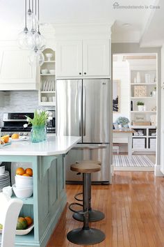 a kitchen with white cabinets and wooden floors