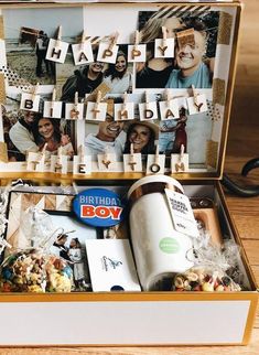 an open box filled with pictures and letters on clothes pegs to spell out the word happy birthday