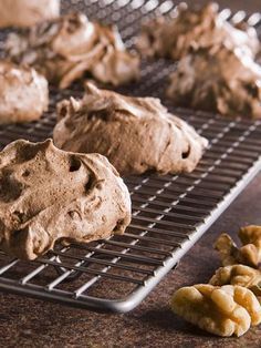 chocolate cookies cooling on a wire rack next to some walnuts and other food items