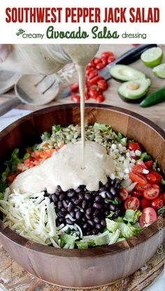 a wooden bowl filled with salad and dressing