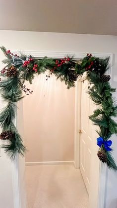 a doorway decorated with pine cones, holly and red berries