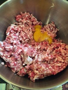 a metal bowl filled with meat and eggs