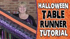 a woman holding up a halloween table runner