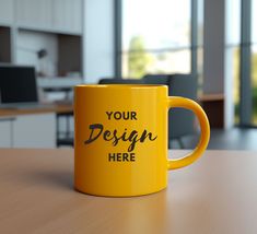 a yellow coffee mug sitting on top of a wooden table next to a computer desk