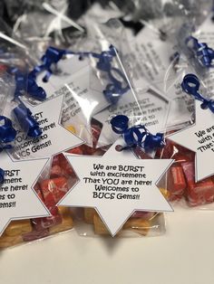 small candy candies are wrapped in plastic and tied with blue ribbon to give them as favors