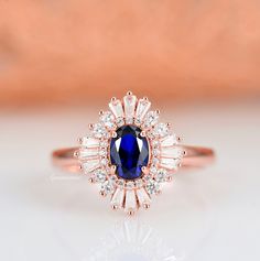 Gorgeous vintage inspired sapphire ring made of 14k rose gold over 925 solid sterling silver, making a simple but elegant statement piece. This ring is perfect to wear as engagement ring, promise ring, or birthstone ring. Main Stone: Sapphire Stone Creation: 100% genuine lab-grown Color: Blue Stone Cut: Oval Gem size: 7.0 x 5.0 mm Carat Weight: 1 ct. (approx.) Hardness: 9-9.5 (Mohs scale) ►Accented With Simulated Diamonds (CZ) ►Please be aware that plated jewelry can wear off over time, if this 14k Rose Gold Wedding Ring With Center Stone, Heirloom Sapphire Ring With Halo Design For Anniversary, Classic Rose Gold Solitaire Sapphire Ring, Classic 14k Rose Gold Rings With Halo Design, Classic 14k Rose Gold Rings For Anniversary, Classic 14k Rose Gold Halo Rings, Classic 14k Rose Gold Anniversary Rings, 14k Rose Gold Rings With Center Stone For Anniversary, Wedding Ring In 14k Rose Gold With Halo Setting