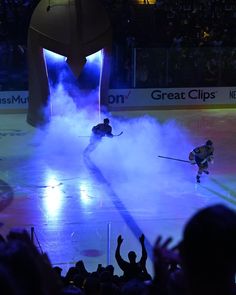 two hockey players are playing on the ice in front of an audience at a sporting event