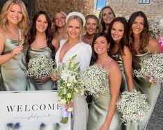 a group of women standing next to each other holding bouquets in their hands and posing for the camera