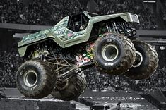 a monster truck is in mid air over the crowd