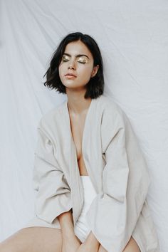 a woman sitting on top of a white sheet