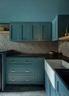 a kitchen with blue cabinets and black counter tops