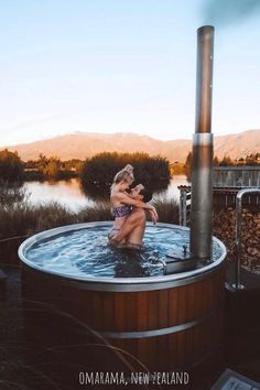 a woman in a hot tub with mountains in the background