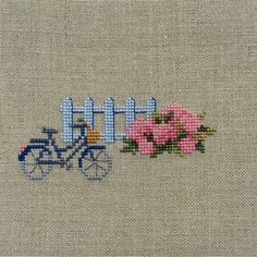 a cross stitch pattern with pink flowers and a blue bicycle on the side that says little