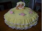 a doll sitting on top of a table wearing a yellow dress with pink flowers in the center