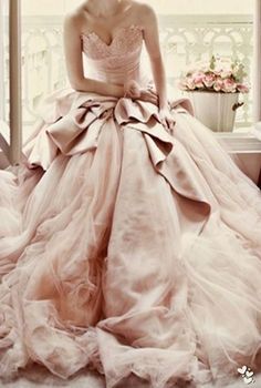 a woman in a ball gown sitting on a window sill