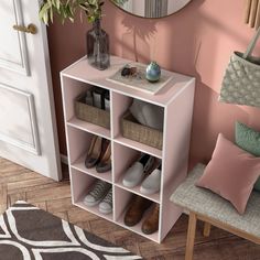 a white shelf with baskets and shoes on it next to a pink wall in a living room