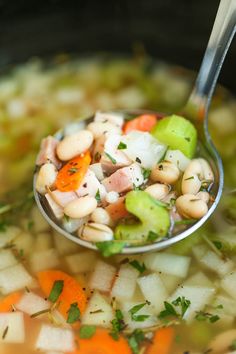 a spoon full of soup with vegetables and meat