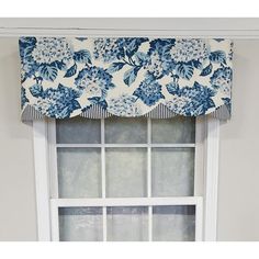 a blue and white flowered valance hanging on the side of a window