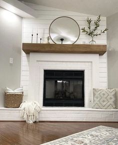 a living room with a fire place and white painted brick fireplace mantel above it