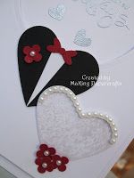 a close up of a greeting card with two hearts and flowers on the front side