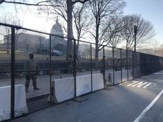 two soldiers standing behind a fence in front of a building