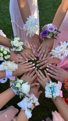 a group of people holding their hands together in the middle of a circle with flowers on them