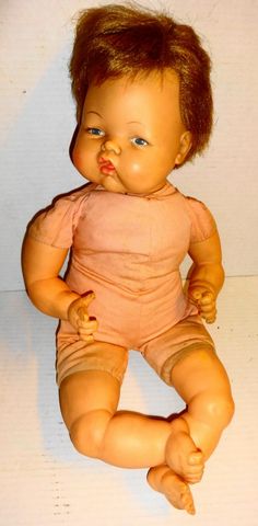 a baby doll sitting on top of a white table