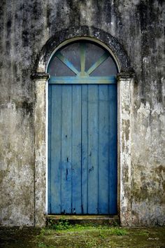 an old building with a blue door and arched window