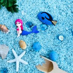 various sea animals and seashells are scattered on the blue carpet, including starfish