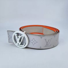 This reversible Louis Vuitton belt is composed of Antarctica White Monogram Canvas and leather and features a neon orange leather trim and a white circled LV initials belt buckle. Model: M0169S Color: White & Orange Material: Antarctica White Monogram Canvas & Leather Made in: Spain Size: 38" / 95 cm, Width: 40 mm Condition: NEW with dust bag & box. Size: 40" / 100 cm, Width: 40 mm Condition: NEW with dust bag & box. Designer White Leather Belts, Luxury Leather Belt With Logo Strap, Designer White Belt For Formal Occasions, Designer White Belts For Formal Occasion, Modern White Belt For Formal Occasions, Modern White Formal Belt, Circle Belt, Orange Material, Louis Vuitton Belt