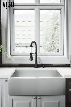 a kitchen sink sitting under a window in front of a counter top with a faucet