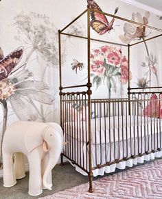 a baby's room with an elephant, bed and wallpaper on the walls