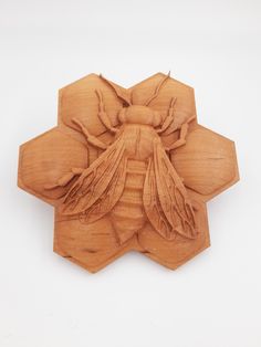 a bee carved from wood on a white background