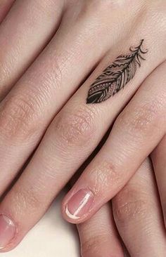 two fingers with tattoos on them, one has a feather and the other has an arrow