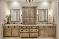 a large bathroom with double sinks and wooden cabinets