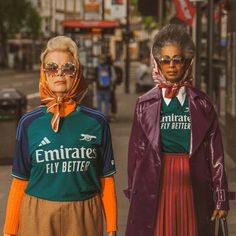 two women in matching outfits walking down the street