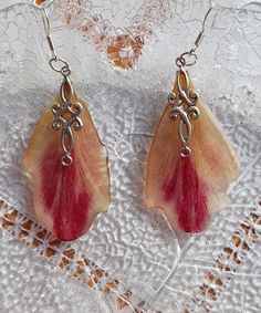 This is a beautiful handmade dangle earrings with real Tulip petals embedded in crystal clear resin. This elegant dangle earring is made with hypoallergenic silver plated earring hooks. This nature inspired jewelry is a delicate piece of nature and will be a nice gift for Mother's Day, Valentine's Day or any occasion. This jewelry could be a perfect gift for any nature lover.. This unique handmade natural jewelry was designed for you to compliment your beauty. This item arrives in a small handmade gift package. Please note: may contain small bubbles or imperfections. Resin jewelry is not waterproof! I recommend to avoid direct contact with water. Thank you for visiting my shop! Handmade Petal Shaped Earrings, Handmade Petal-shaped Earrings, Silver Pressed Flower Resin Earrings, Silver Pressed Flower Earrings In Resin, Silver Resin Earrings With Pressed Flowers, Handmade Silver Resin Flower Earrings, Tulip Petals, Tulip Earrings, Framed Wedding Photos