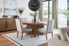 a dining room table surrounded by chairs and vases